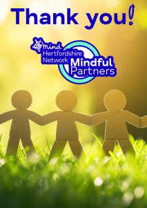 the picture shows a cardboard cut out of four stick men joined together, standing on grass. The caption reads Thank You! Mindful Partners